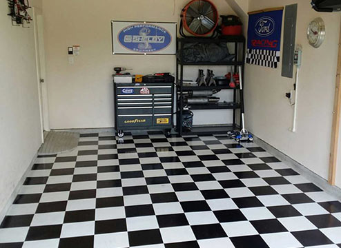 Black and white checkered peel & stick vinyl floor tiles in garage